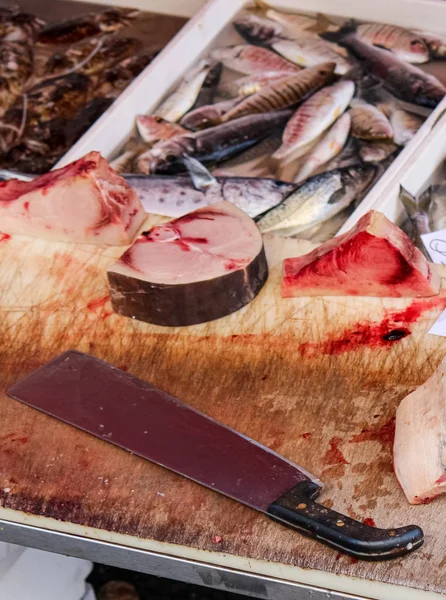 Fotografía de cerca de peces muertos en rodajas en una mesa de madera con sangre y cuchilla grande. Concepto de abuso animal, crueldad con los animales. Conservación de especies amenazadas. Problema global. Foto: Catania, IT —  Fotos de Stock