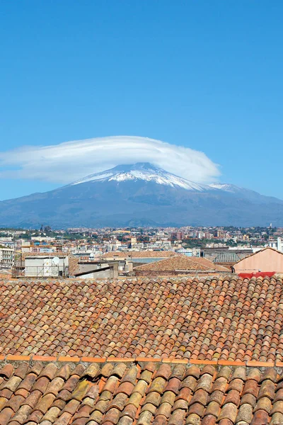 Arka planda ünlü Etna Yanardağı ile Catania, Sicilya, İtalya güzel şehir manzarası yakalayan dikey fotoğraf. Tarihi binaların çatıları. Dağın en tepesinde kar