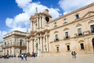 Syracuse, Italya-10 Nisan 2019: komşu meydanda turistler ile Sicilya 'da Syracuse güzel Roma Katolik Katedrali. Kilise, UNESCO Dünya Mirası 'nün bir parçasıdır. Popüler turistik cazibe