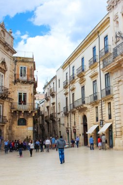 Syracuse, Sicilya, İtalya - Nis 10th 2019: Turistler eski şehirde Piazza Duomo Meydanı'nda yürüyüş. Güzel şehrin tarihi merkezi ünlü Ortigia Adası'nda yer almaktadır. Popüler nokta