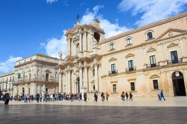 Syracuse, Sicilya, İtalya - Nis 10th 2019: Ortigia Adası'ndaki Piazza Duomo Meydanı'ndaki Syracuse Katedrali'nin muhteşem manzarası. Meydanda yürüyen turistlerle fotoğraflandı. Güzel turistik site
