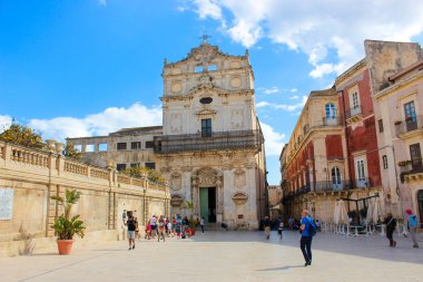 Syracuse, Sicilya, İtalya - Nis 10th 2019: Etkileyici Santa Lucia Alla Badia Kilisesi önünde Piazza Duomo Meydanı'nda yürüyen insanlar. Popüler turistik yer. Gezi