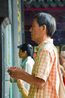 Taipei Tayvan - 13 Mayıs 2017: Longshan Tapınağı'nda dua sopalarla dua eden yaşlı Asyalı adam. Dini törenler, din ayinleri. Budist duası. İnanç kavramı