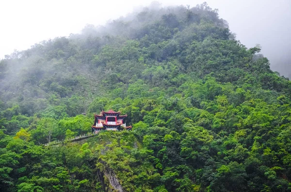 Magnifico tempio cinese su una ripida roccia circondata da una verde foresta tropicale. Tempo nebbioso, nebbia. Paesaggio taiwanese, viaggi in Cina. Natura cinese. Bellissimo santuario, concetto religioso — Foto Stock