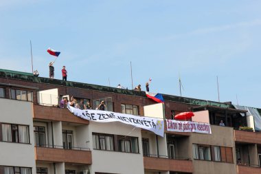 Prag, Çek Cumhuriyeti - 23 Haziran 2019: Letna,Letenska planı üzerinde Başbakan Babis ve Adalet Bakanı protestoları destekleyen bir binanın çatısında insanlar. Gösteri, Çek bayrağı