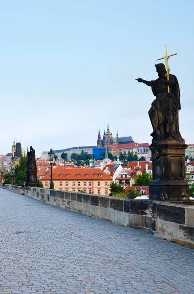 Foto vertical del Puente de Carlos en Praga, Bohemia, República Checa tomada por la mañana temprano en la luz del amanecer sin casi ninguna gente. Castillo de Praga en el fondo. Atracción turística — Foto de Stock