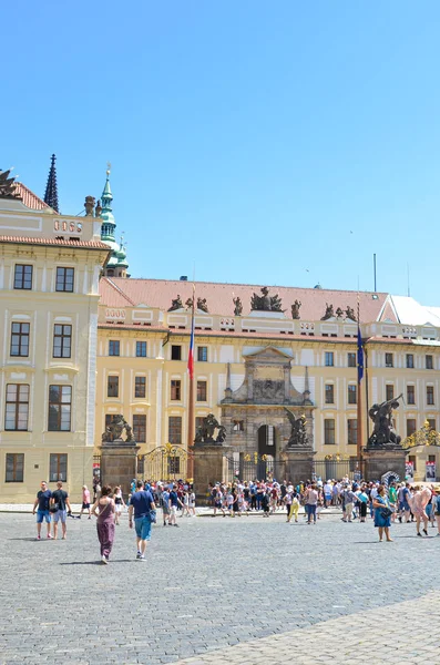 Praga, República Checa - 27 de junio de 2019: Turistas en Hradcanske namesti, Plaza de Hradjalá, frente al famoso Castillo de Praga. Grupo de turismo. Sede del presidente checo. Lugar turístico popular. Chequia — Foto de Stock