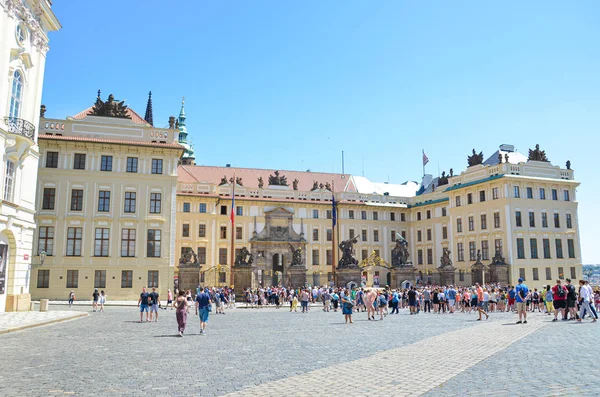 Praga, República Checa - 27 de junio de 2019: Turistas frente al famoso Castillo de Praga en la Plaza de Hradjalá, en la checa Hradcanske namesti. Visitar lugares turísticos. Sede del presidente checo. Lugar turístico popular — Foto de Stock