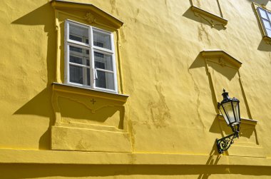Güzel Prag, Çek Cumhuriyeti eski kasabasında tarihi binanın sarı cephe detay. Altın saat fotoğrafçılığı. Güneş cephede parlıyor. Sokak lambası. Madde. Praga, Çekya, Avrupa