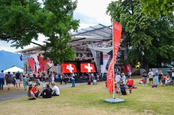 Vevey, Switzerland - Aug 1 2019: People celebrating Swiss National Day in park. Celebration of the founding of the Swiss Confederacy. Independence day. Switzerland flags decoration, screens — Stock Photo, Image