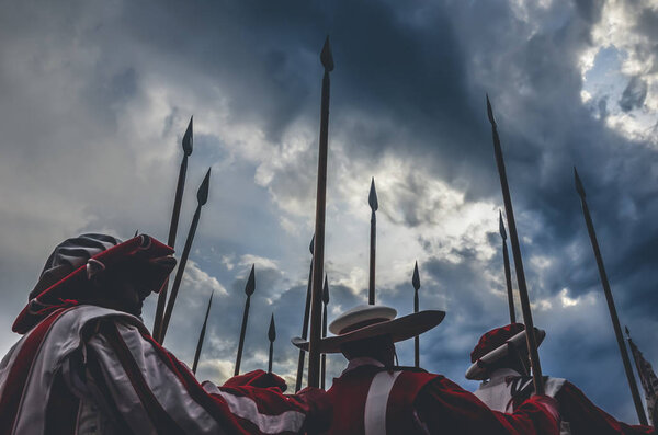 Средневековые рыцари держат копье наготове к битве. Красно-белая униформа. Сфотографирован с драматическим небом перед бурей. Борьба, армейская концепция, концептуальная. История, исторический фон
