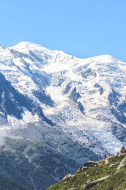 Alpler, Fransa Chamonix yakınlarındaki inanılmaz Mount Blanc bakan bir kayanın üstünde Yürüyüşçüler. Fransız Alpleri ve Avrupa'nın en yüksek zirvesi. Yaz sezonu. Macera, yürüyüş konsepti. Turistik yerler
