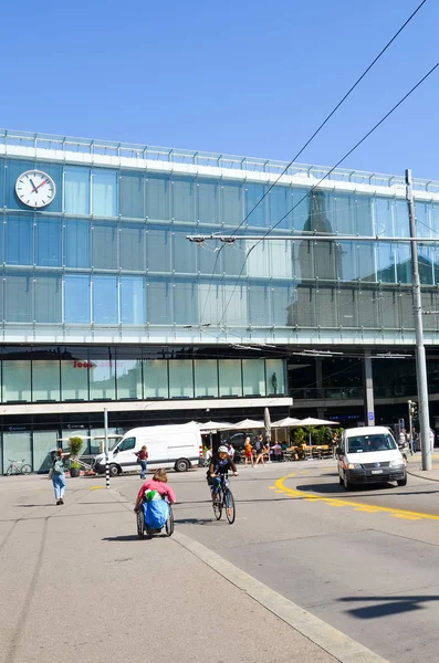 Berna, Svizzera - 14 agosto 2019: costruzione della principale stazione ferroviaria della capitale svizzera fotografata dall'esterno con persone per strada e auto sulla strada adiacente. Quadro verticale — Foto Stock