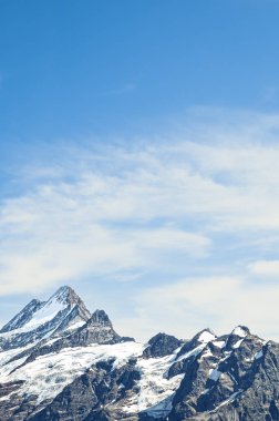 Mavi gökyüzü ve ışık bulutları ile Alp dağ zirveleri. Dağ tırmanışı, dağlar. Kopya alanı, metin için bir yer. Motivasyonel arka plan. Sıkı çalışma. Kişisel gelişim. Konsepti keşfedin