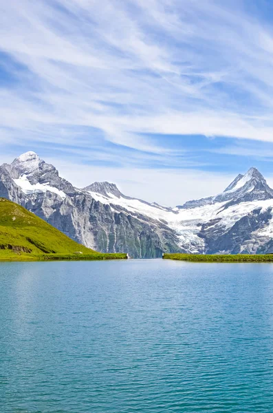 İsviçre Alpleri Grindelwald yakınlarındaki inanılmaz Bachalpsee dikey resim ünlü dağ zirveleri Eiger, Jungfrau ve Monch ile fotoğraflandı. Alp gölü, manzara. İsviçre, karla kaplı dağlar