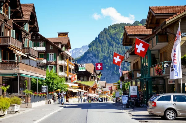 Lauterbrunnen, Švýcarsko-červenec 16 2019: hlavní ulice v malebné alpské vesnici Lauterbrunnen fotografované v letní sezóně. Tradiční dřevěné chaty, obchody, restaurace, lidé — Stock fotografie