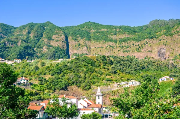 Aldeia montanhosa pitoresca São Vicente na Madeira, Portugal. A pequena cidade é cercada por colinas verdes íngremes. Campos com terraço, rochas, paisagem montanhosa. Ilha portuguesa no oceano Atlântico — Fotografia de Stock