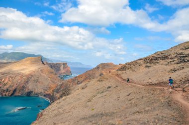 Portekiz, Madeira Adası, Ponta de Sao Lourenco 'daki muhteşem uçurumlar. Madeira adasının en doğu noktası, Atlantik Okyanusu 'nun yanındaki volkanik manzara. Yürüyüşçüler doğa yürüyüşü yolunda. İz