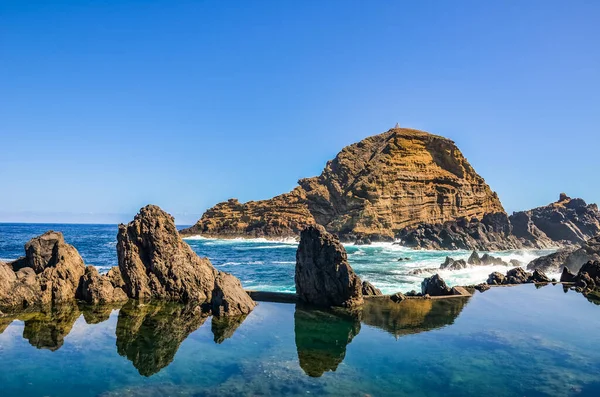 Incríveis piscinas naturais no Oceano Atlântico, Ilha da Madeira, Portugal. Feito de rocha vulcânica, para a qual o mar flui naturalmente. Atração turística e destino de férias de verão — Fotografia de Stock