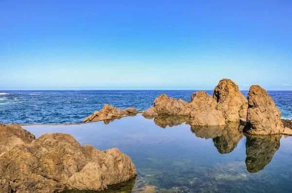 大西洋の天然スイミングプール,ポルト・モニス,マデイラ島,ポルトガル.海が自然に流れる火山岩で構成されています。素晴らしい夏の休暇のスポット。ポルトガルの島 — ストック写真