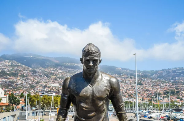 Funchal, Madeira, Portekiz - 14 Şubat 2019: Portekiz Funchal 'daki ünlü futbolcu Cristiano Ronaldo' nun Bronz Heykeli. Funchal şehri ve arka planda liman. Cr7 Müzesi 'nin bir parçası. Futbol, spor