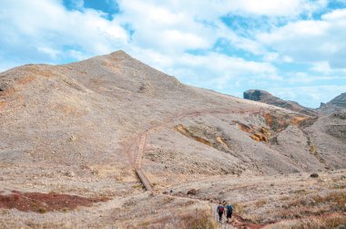 Portekiz 'in Madeira kentindeki Ponta de Sao Lourenco' ya giden yürüyüş parkurundaki insanlar. Portekiz adasının en doğu noktası. Volkanik manzara. Tepe arazisi. Volkanik toprak. Yürüyüşçüler yolda