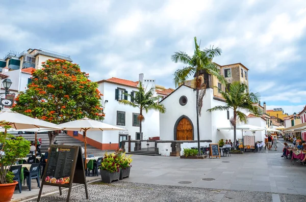 Funchal, Madeira, Portugal - 10 de setembro de 2019: Rua na capital madeirense com restaurantes e cafés típicos. Pessoas bebendo e comendo em terraços ao ar livre. Arquitetura colonial. Centro histórico — Fotografia de Stock