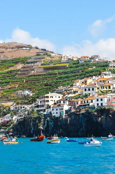 Vissersdorp Camara de Lobos op Madeira, Portugal fotografeerde vanuit de wateren van de Atlantische Oceaan. Stad op een berg aan de kust. Toeristische plaatsen. Bananenplantages op de heuvel — Stockfoto