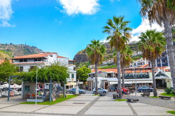 Ribeira Brava, Madeira, Portugal - Sep 9, 2019: Promenade of the Madeiran city photographed from the Atlantic ocean coast. People on the street. Outdoor restaurants, bars, and shops. Palm trees — Stock Photo, Image