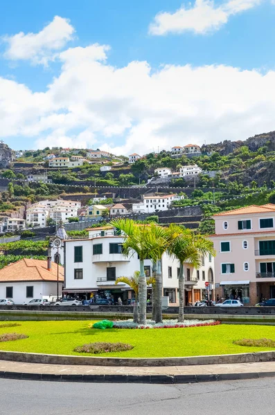 Ribeira Brava, Madeira, Portugal - 9 sep 2019: Stadscentrum op een verticale foto met palmbomen. Gebouwen op de heuvels op de achtergrond. Groene bomen en bananenplantages tussen de huizen — Stockfoto