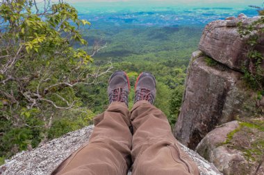 Bacaklar boots dağ dağlar ve vadiler gürültülü bulutlar ile fon karşı izleme için dinlenme bir adamın dağlarda yürüyüş önyükleme yapar. Dinlenme zamanı. Özgürlük kavramı