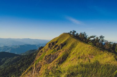 İlkbahar gün batımı dağların üzerinden. tepeler haddeleme üzerinde tarım alanları ile güzel bir kırsal manzara