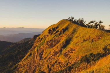 İlkbahar gün batımı dağların üzerinden. tepeler haddeleme üzerinde tarım alanları ile güzel bir kırsal manzara