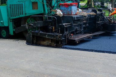 Yol inşaat ekibi yeni bir şeritli karayolu üzerinde zemin hazırlıyor.