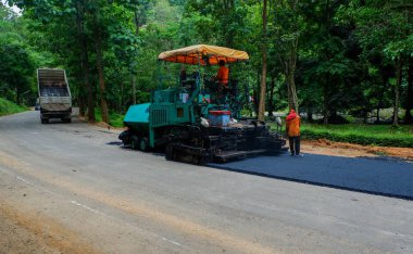 Yol inşaat ekibi yeni bir şeritli karayolu üzerinde zemin hazırlıyor.