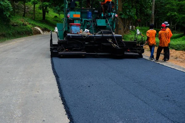 Road construction crew paves a new lane on the highway