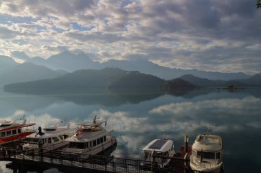 Güneş ay göl manzarası ile çok sayıda piers bekleyen yolcu tekneleri