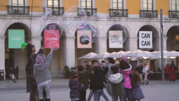 リスボン ポルトガル 子供たちが石鹸半透明の球を吹き飛ばす楽しみを持っている子供のための大きな大きな大きな石鹸の泡を作成するストリートアーティスト — ストック動画