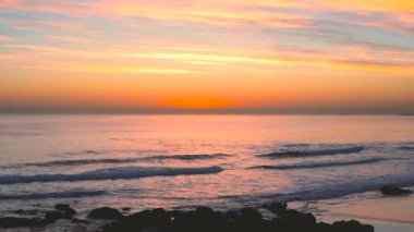 Carcavelos plajda su yüzeyinde günbatımı yansımaları ile güzel Atlantik okyanusu dalgaları,