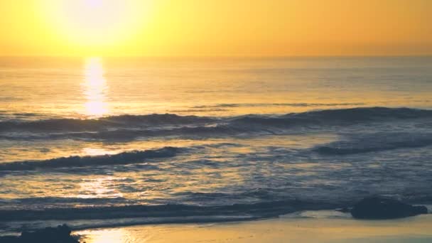 Κύματα στο βαθύ κίτρινο ηλιοβασίλεμα με νερό αντανακλάσεις, παραλία Carcavelos, Πορτογαλία — Αρχείο Βίντεο