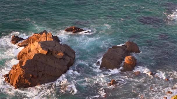 Olas rompiendo en cámara lenta contra dos enormes rocas en el agua — Vídeo de stock