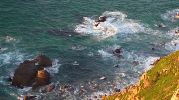 Vågor som bryter i slow motion mot två stora stenblock i vattnet — Stockvideo