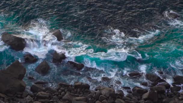 Hullámok törés erózió gyengülő sötét bazalt sziklák közelében Shore. — Stock videók