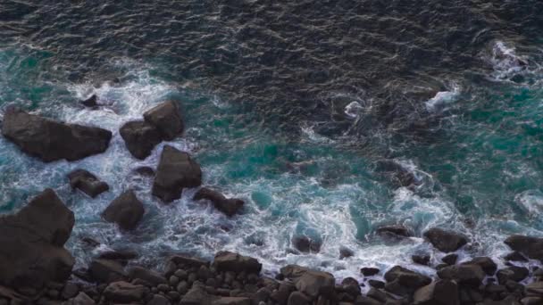 Волны, разрушающие эрозию темных базальтовых пород вблизи берега . — стоковое видео