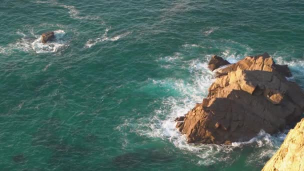 Olas rompiendo en cámara lenta contra dos enormes rocas en el agua — Vídeo de stock