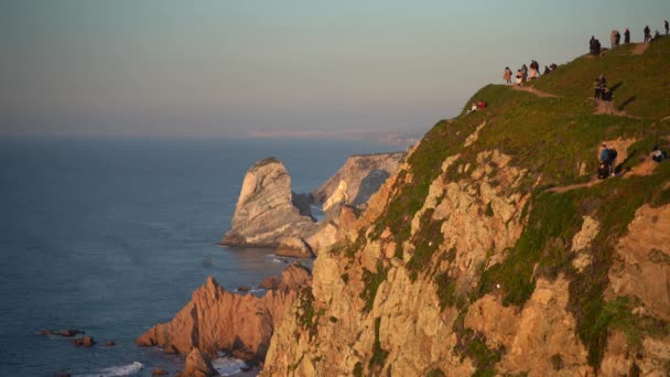 Cape Roca, Portekiz'deki tehlikeli uçurumun yakınında yürüyen insanlar. — Stok video