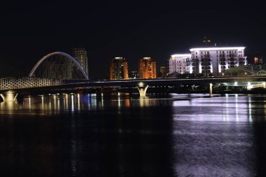 Astana (Nur-Sultan), Kazakistan: Astana 'daki ISHIM nehrindeki modern binalarla gece görüşü (Nur-Sultan)
