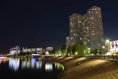 Astana (Nur-Sultan), Kazakistan: Astana 'daki ISHIM nehrindeki modern binalarla gece görüşü (Nur-Sultan)