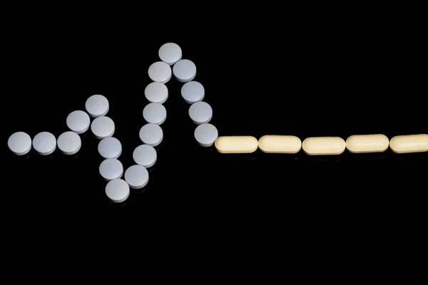 Medicines white, round heart shaped pills  on black  background.