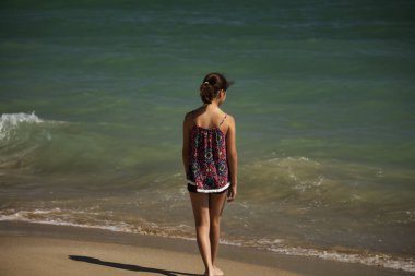 sahilde duran ve se içine bakarak güzel bir kız